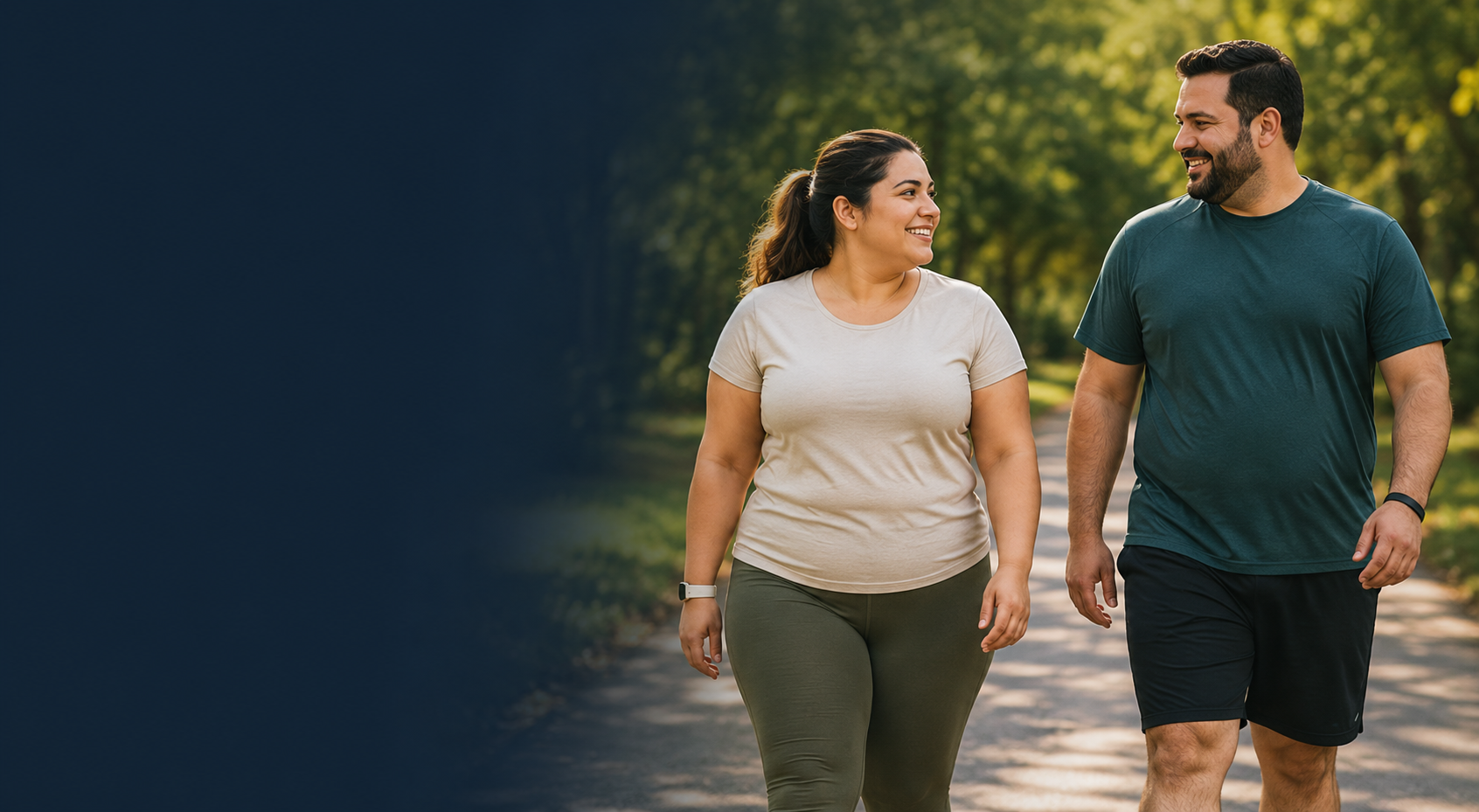 A woman and a man in activewear walking together and smiling on a tree-lined path